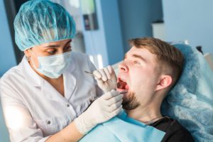 牙周病 3 dentist-doing-a-dental-treatment-on-a-patient-P7H2UAX