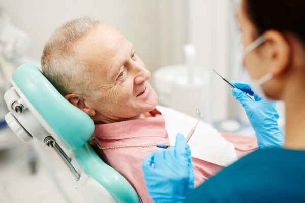 Aged man complaining about problems with teeth before dental check-up