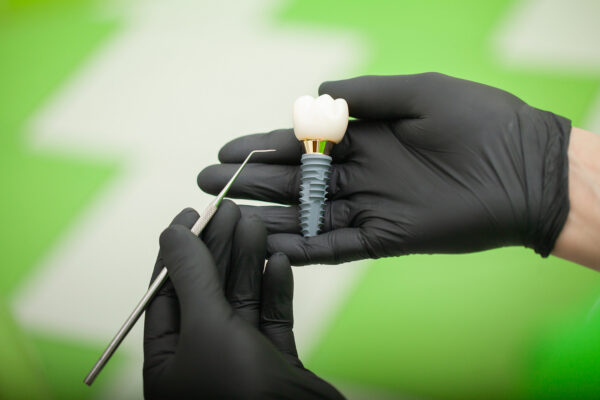 Dentist explaining teeth model to female patient. Technical shots on a dental prothetic laboratory.