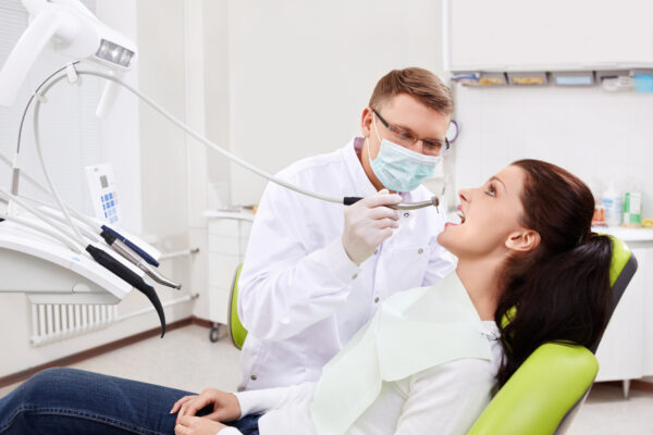 The dentist treats teeth of the patient in the clinic