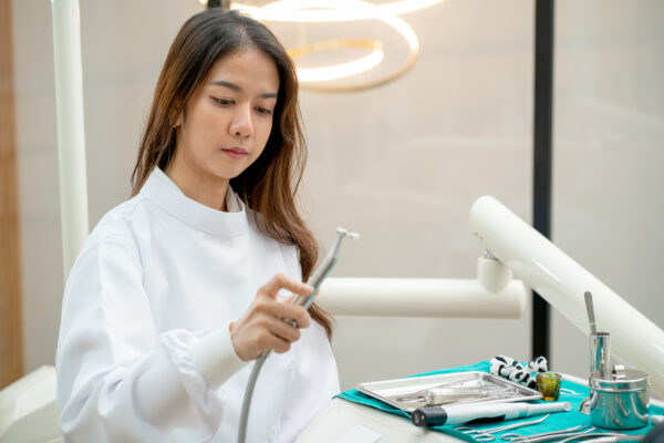 Beautiful Asian dentist woman hold tools for dental process to prepare for patient in dental clinic.