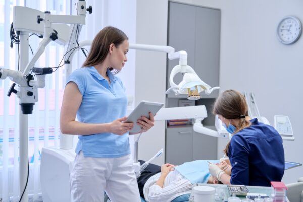 Portrait of dentist doctor with digital tablet, female working with computer. Healthcare dentistry medicine, Dental clinic, patient visit and checkup by dentist background